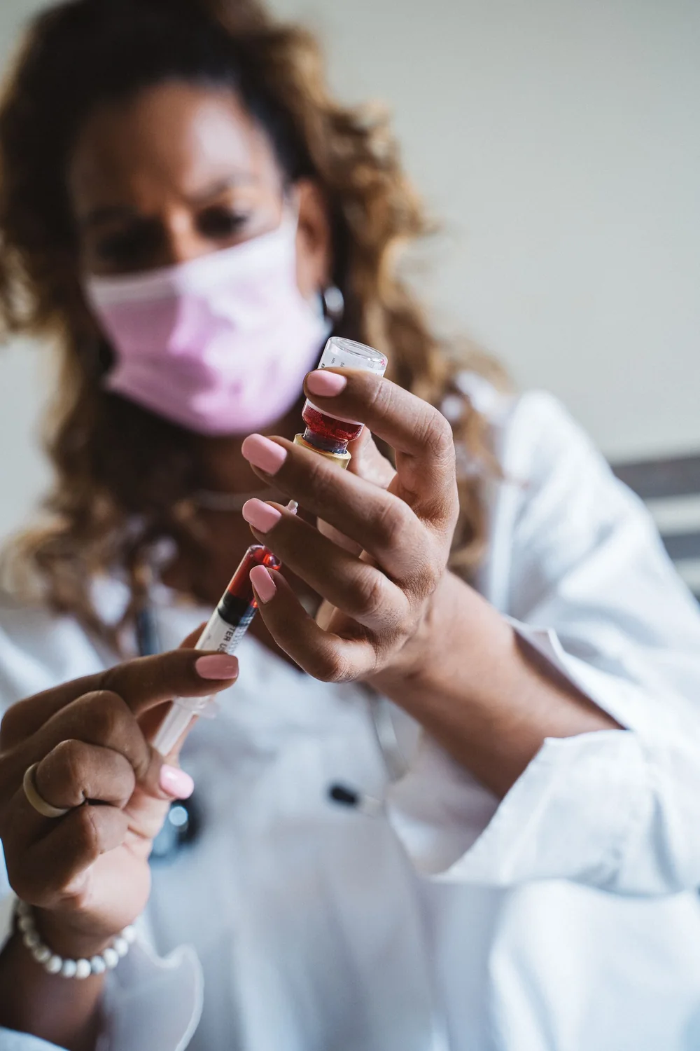Clinician drawing medication from a vial into a syringe